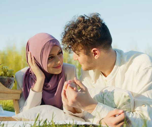 Person stretching gently outdoors, looking energized and happy under the morning sun.